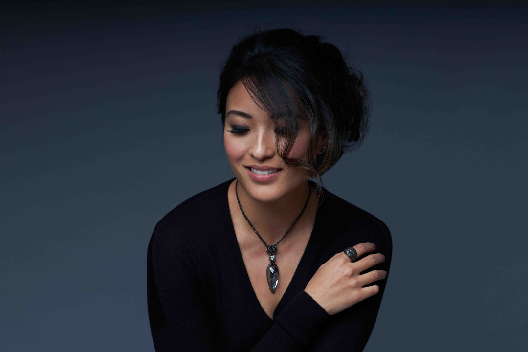 Woman wearing a Moonlight Mystic Quartz pendant, a grounding gemstone necklace with root chakra crystals for feeling overwhelmed.