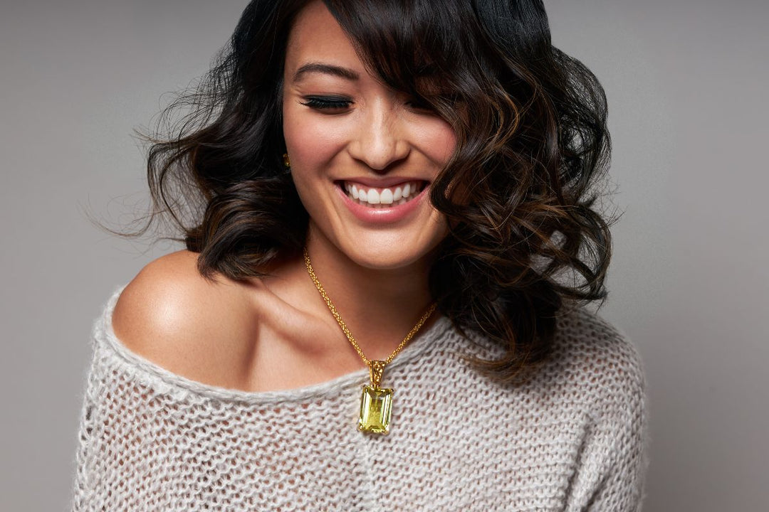 Smiling woman wearing a golden beryl pendant from Kate King Jewellery, representing how to choose the right crystal through vibrational jewellery and healing crystals that align with personal energy and balance.