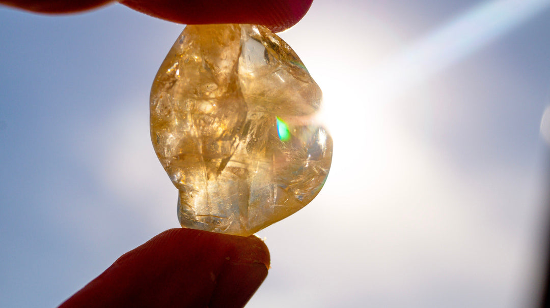 Natural citrine crystal shining under sunlight, showing pale yellow and golden tones that symbolize positivity and citrine crystal benefits.